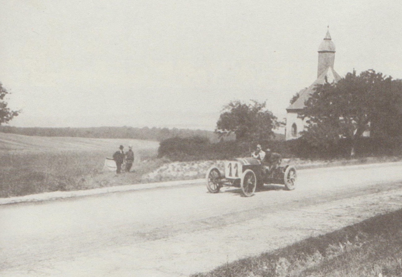 Luigi Storero mit seinem FIAT in voller Fahrt an der Glashüttener Kirche, unterwegs für das italienische Team. Italiens Rennwagenfarbe war übrigens damals Schwarz.